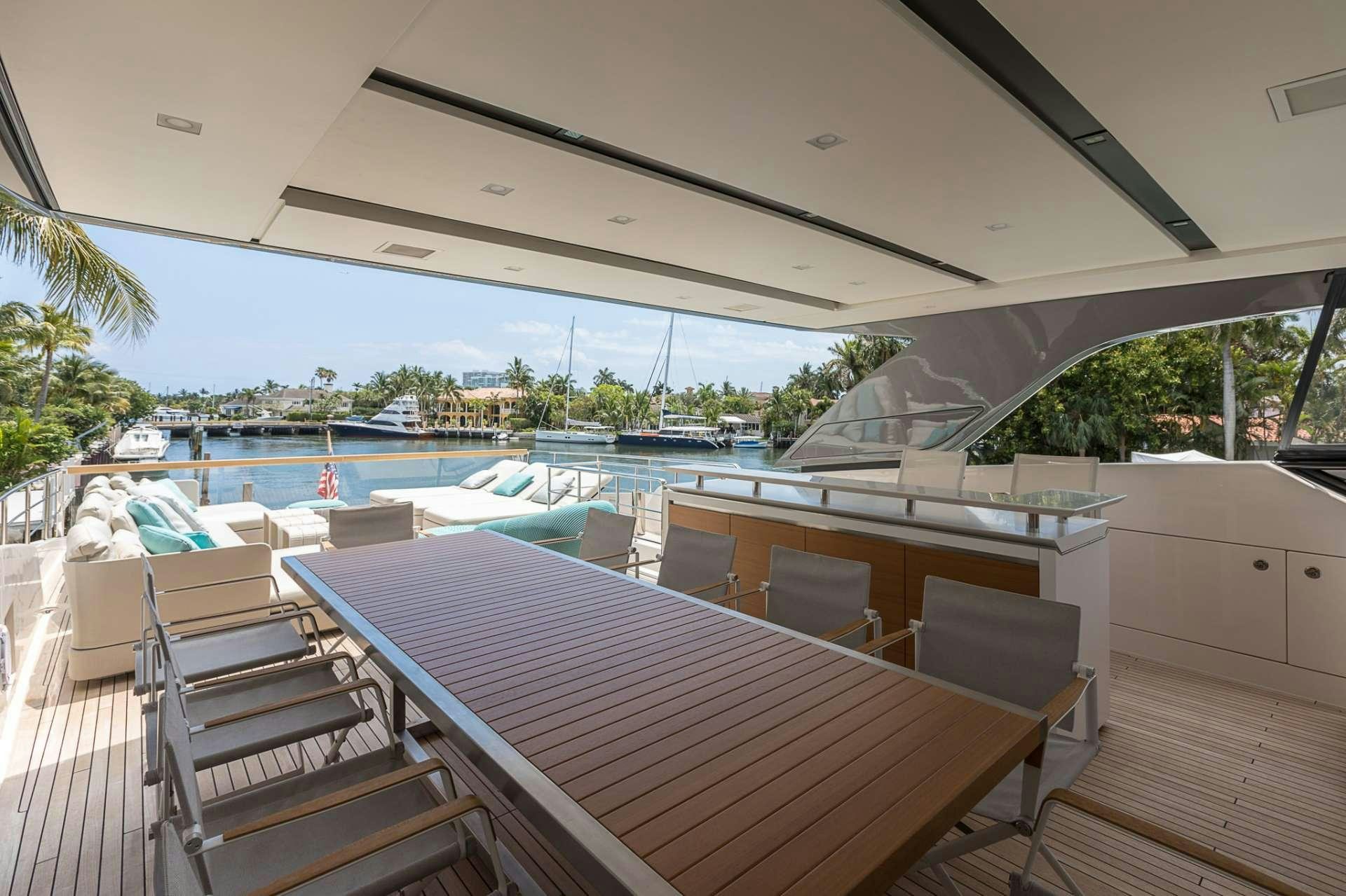a deck with a pool and a deck with chairs and a table aboard NOTORIOUS Yacht for Charter