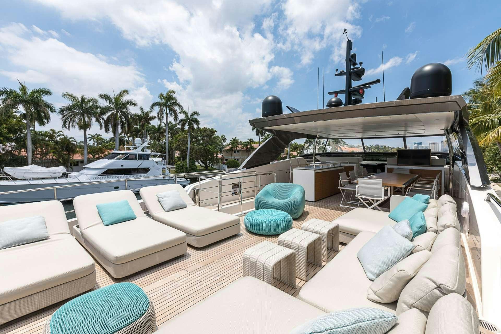 a pool with lounge chairs and a large grill on a sunny day aboard NOTORIOUS Yacht for Charter