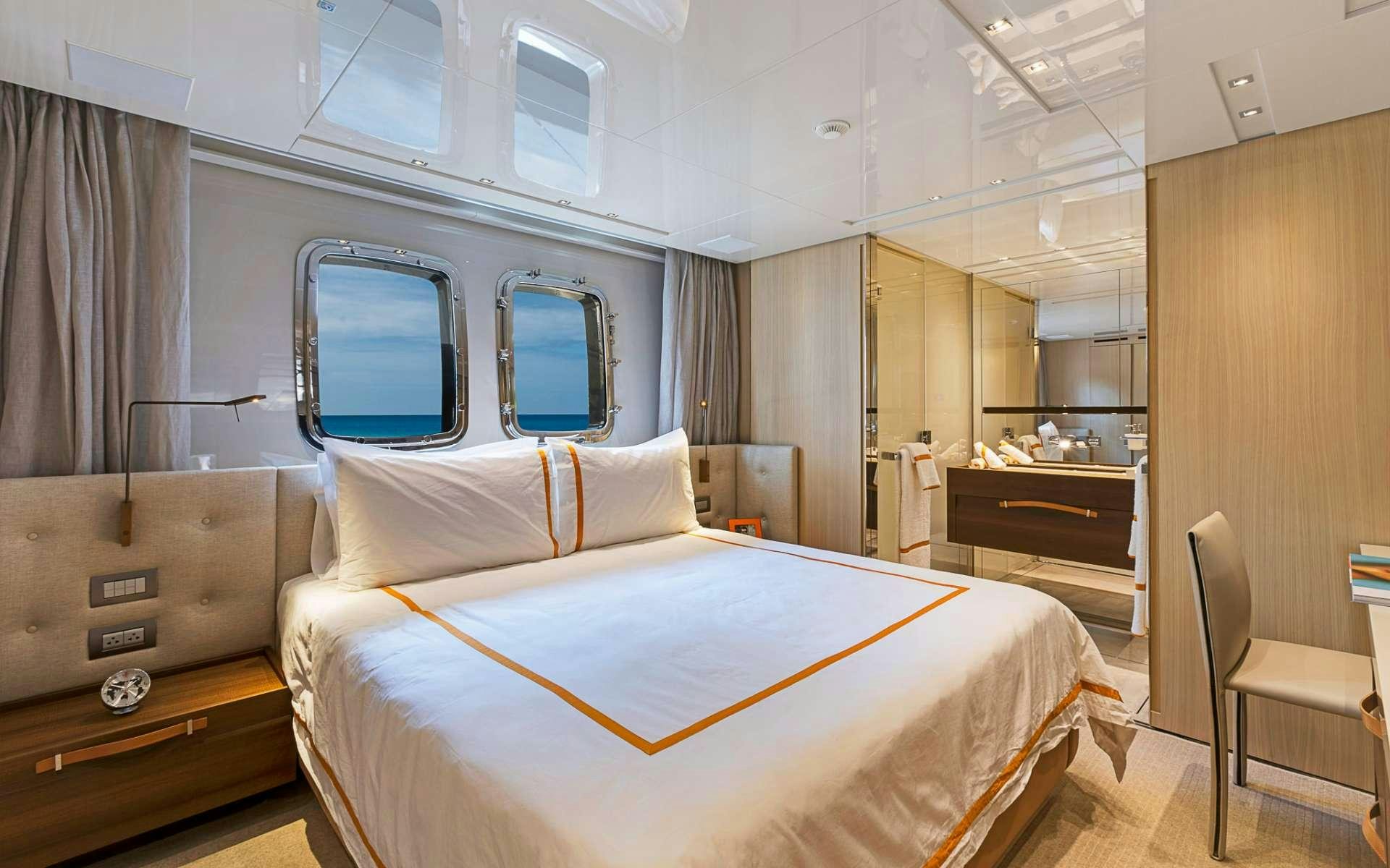 a room with a bed and a desk aboard NOTORIOUS Yacht for Charter