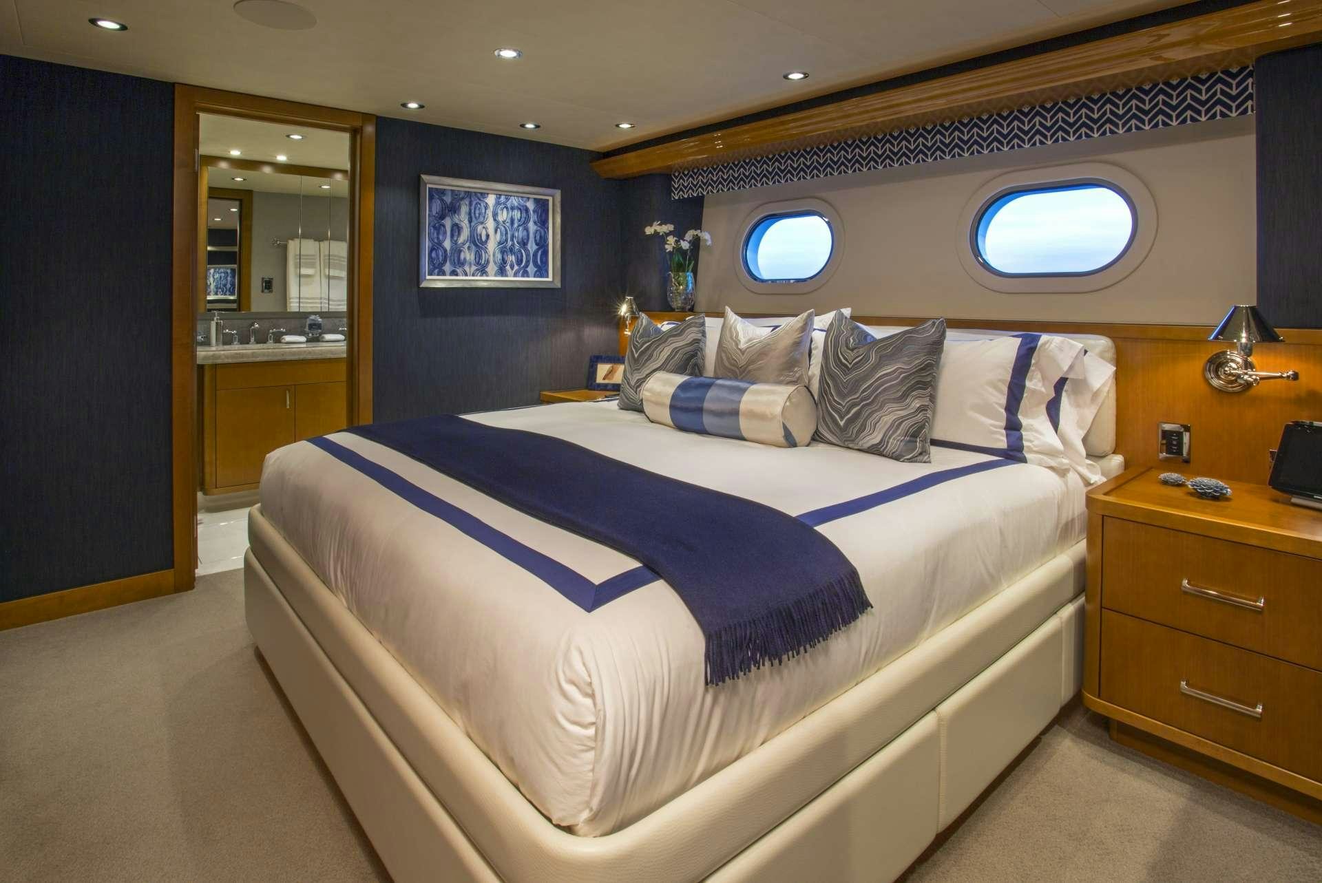 a bed with blue sheets aboard FAR NIENTE Yacht for Charter