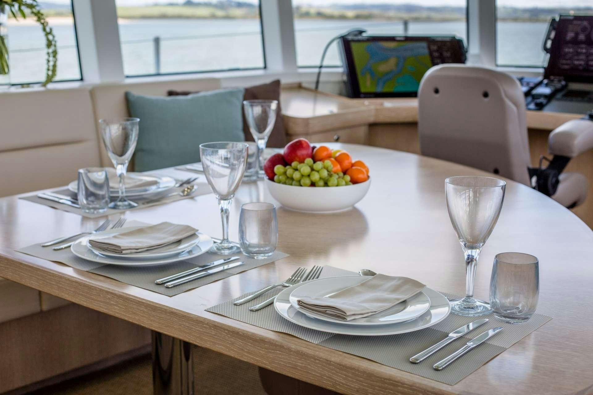 a table with plates and glasses aboard GREY WOLF Yacht for Charter