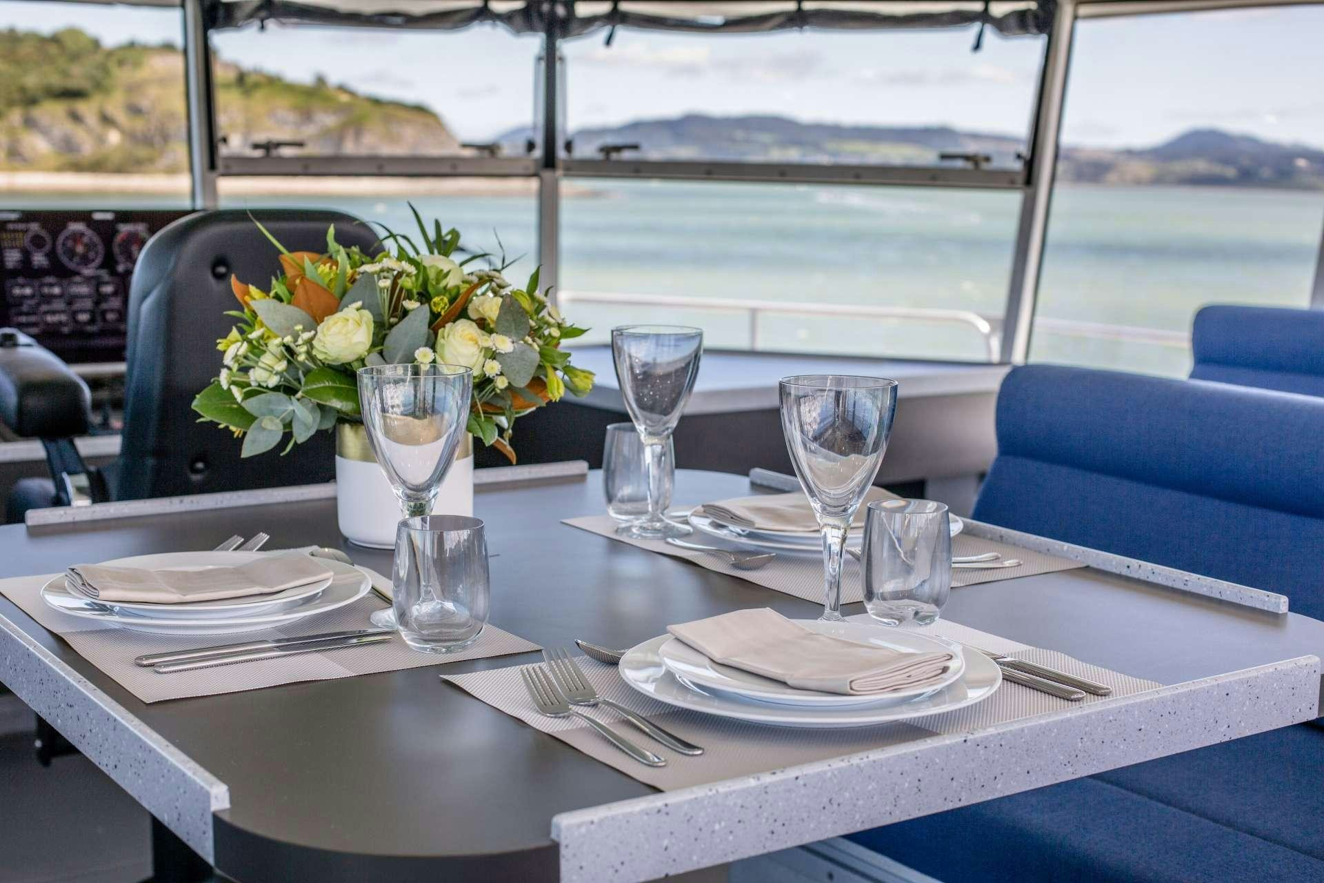 a table with plates and glasses aboard GREY WOLF Yacht for Charter