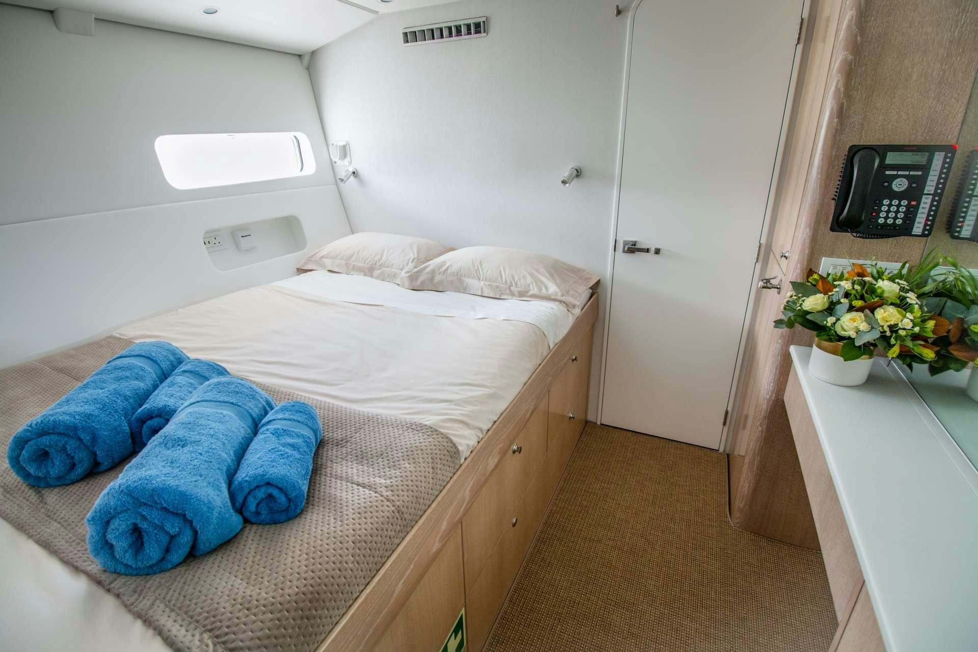 a bed with a blue blanket aboard GREY WOLF Yacht for Charter