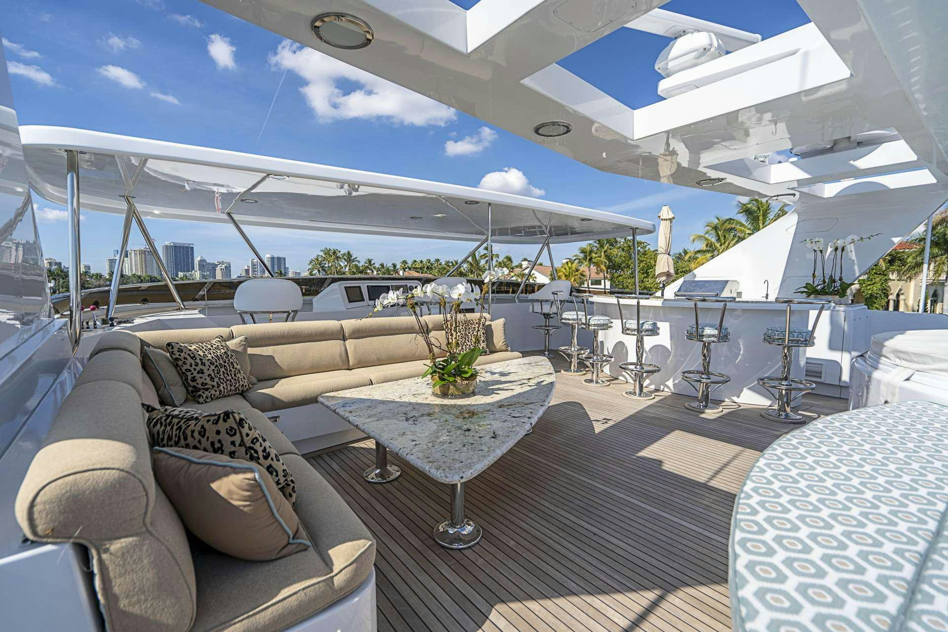 a lounge area with a table and chairs and a large white tent aboard REFLECTIONS Yacht for Charter