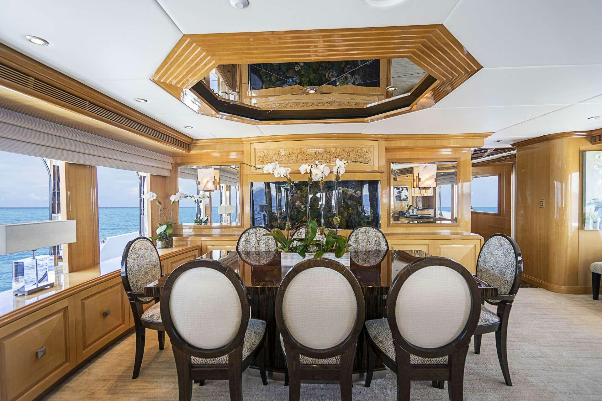 a dining room with a chandelier aboard REFLECTIONS Yacht for Charter
