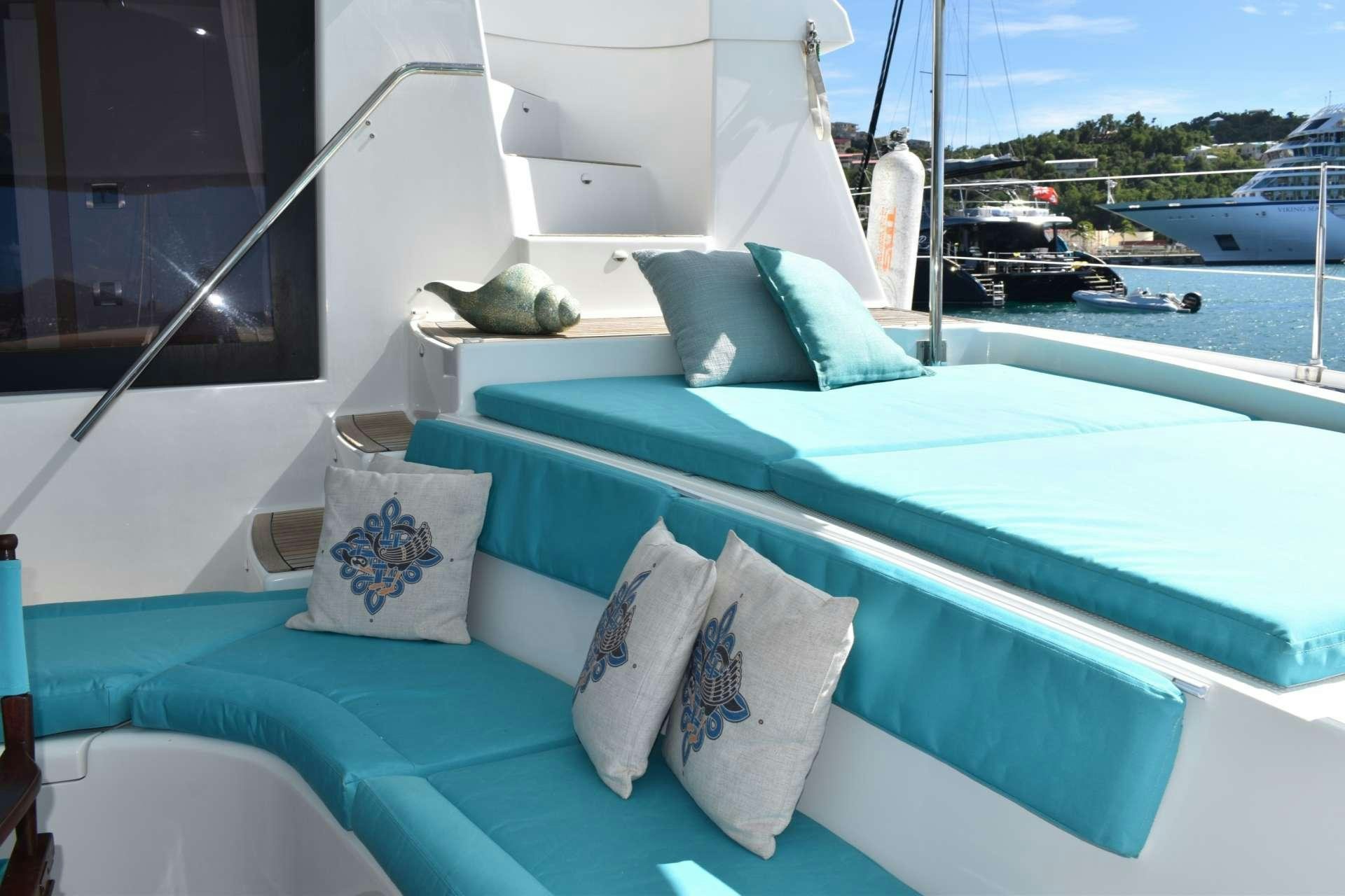 a bed with pillows on it aboard LIR Yacht for Charter