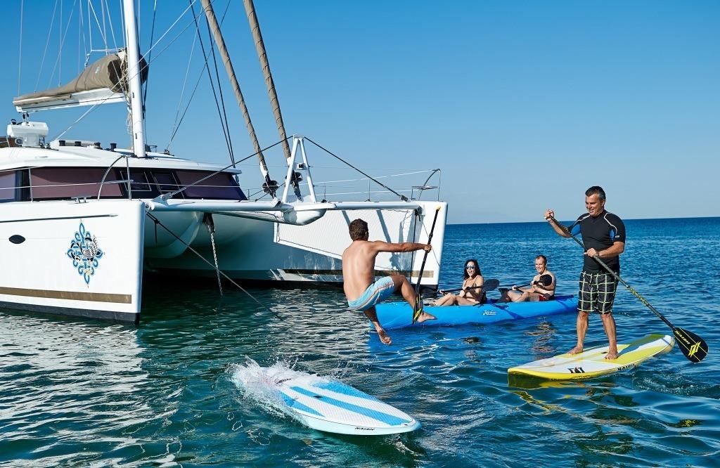 a group of people on surfboards in the water aboard LIR Yacht for Charter