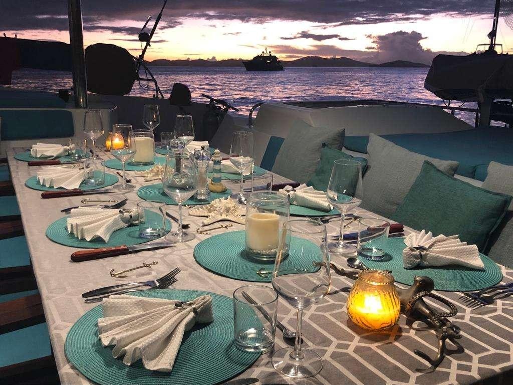 a table with plates and glasses aboard LIR Yacht for Charter