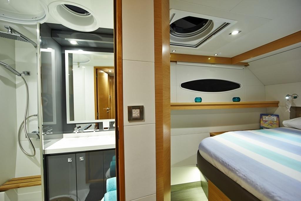a room with a bed and a sink aboard LIR Yacht for Charter