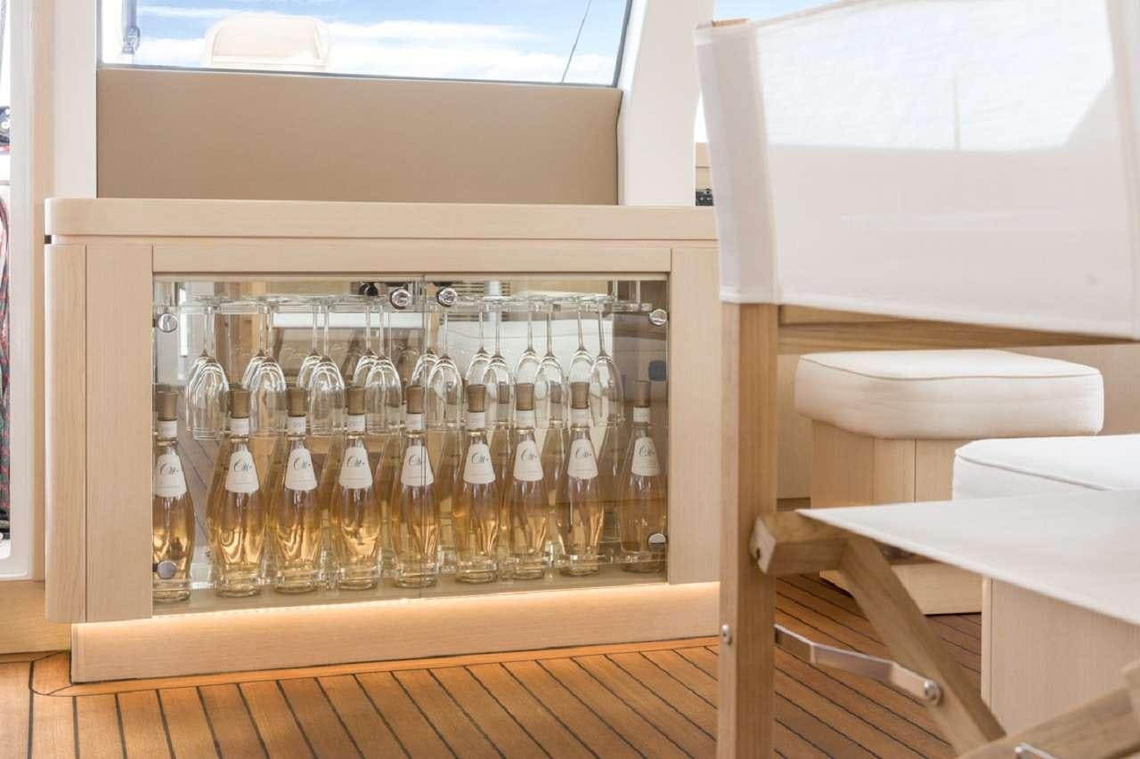 a glass shelf with bottles of alcohol aboard CYGNUS CYGNUS Yacht for Charter