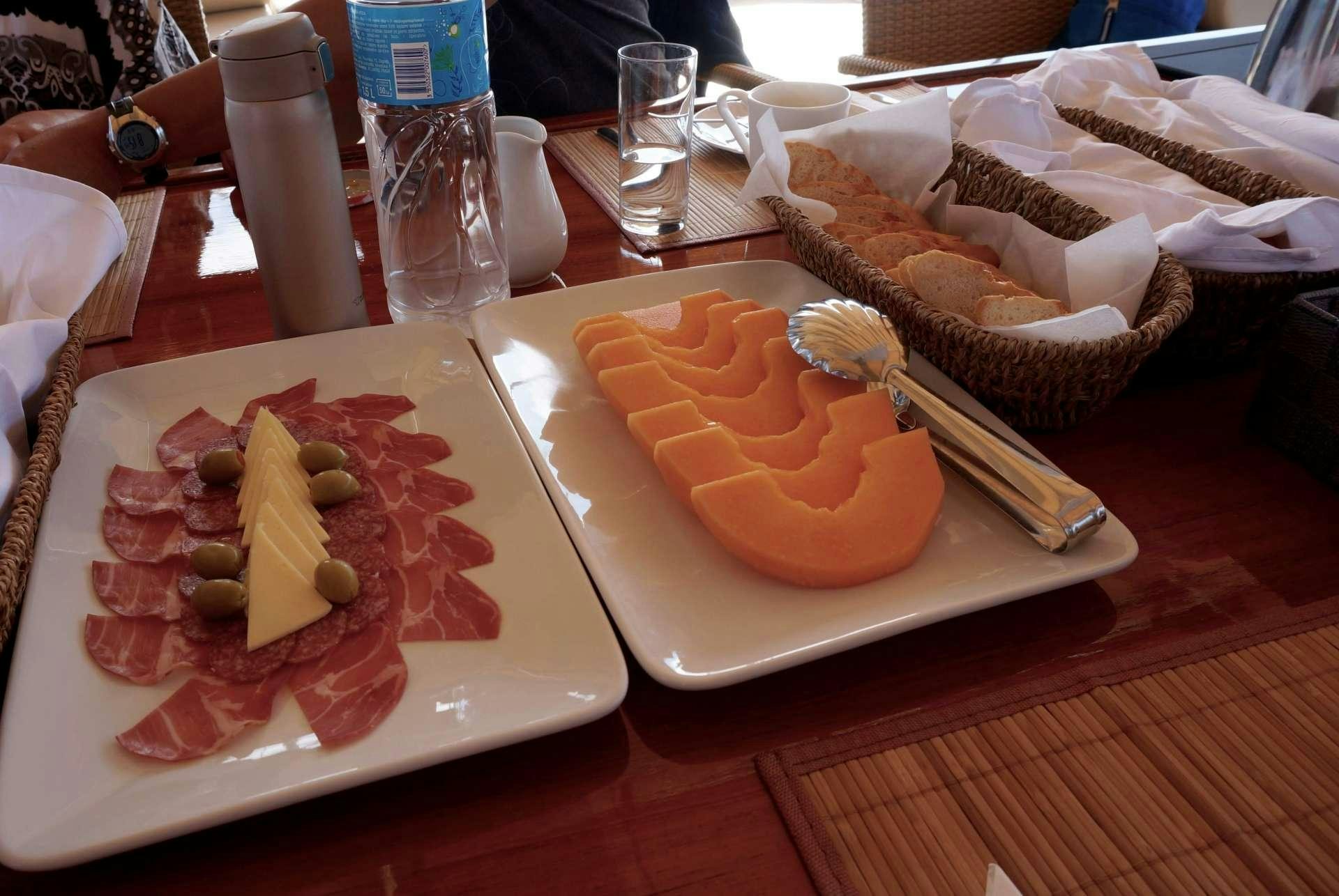 a plate of food and drinks aboard Malena Yacht for Charter