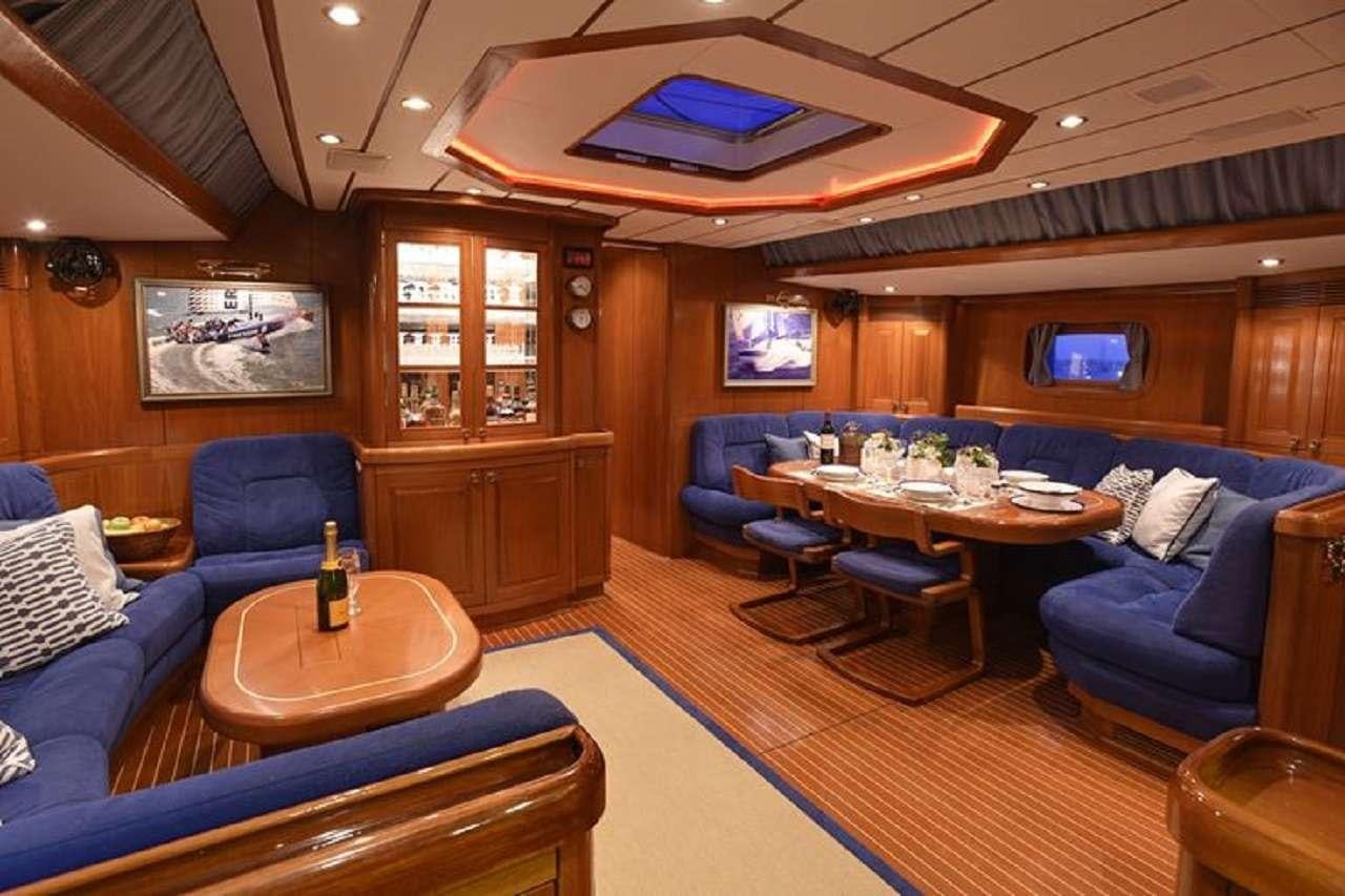 a living room with a table and chairs aboard aquila Yacht for Charter