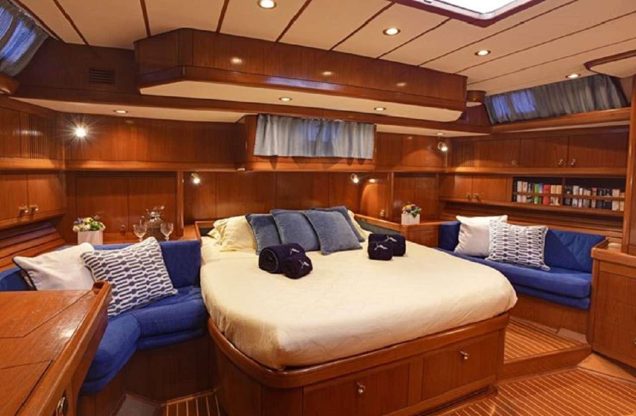 a room with a bed and a couch aboard aquila Yacht for Charter