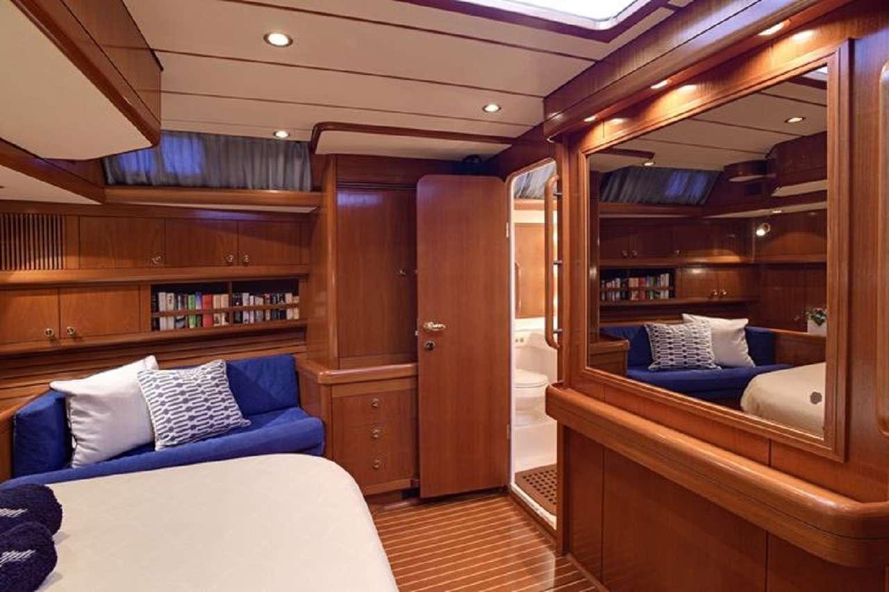 a room with a bed and a bookcase aboard aquila Yacht for Charter