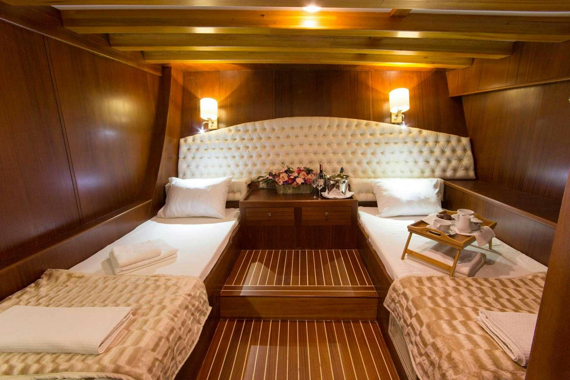a room with a bed and a table aboard ATHENA Yacht for Charter
