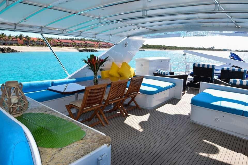 a deck with a table and chairs on it aboard ISLAND VIBES Yacht for Charter