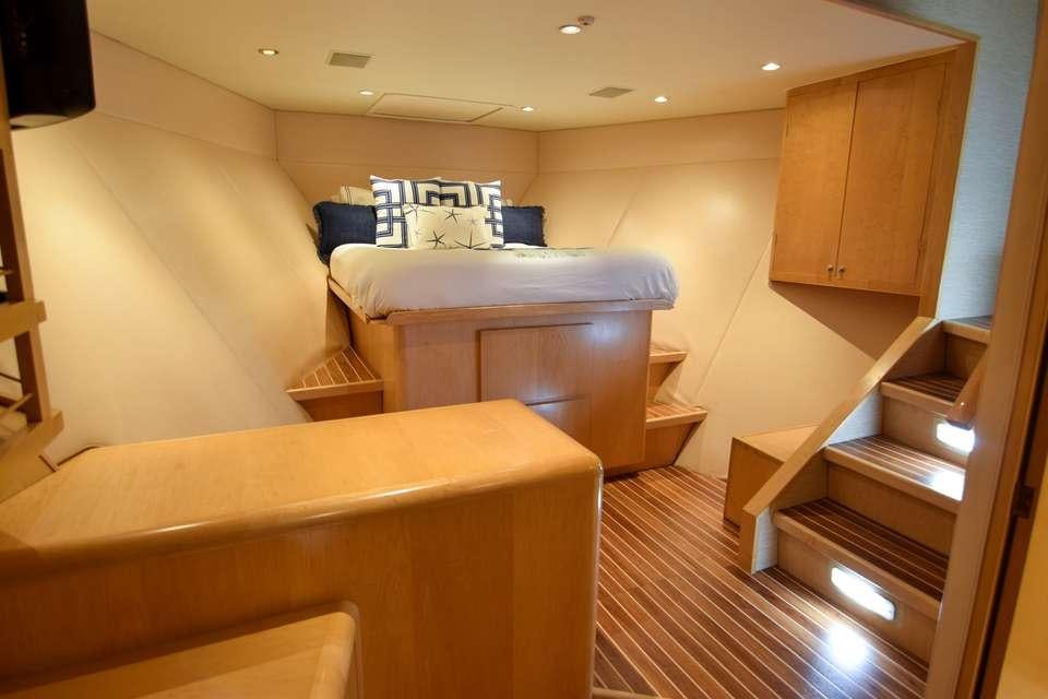 a room with a bed and a dresser aboard ISLAND VIBES Yacht for Charter