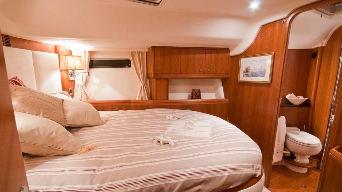 a room with a bed and a mirror aboard MUSTIQUE Yacht for Charter