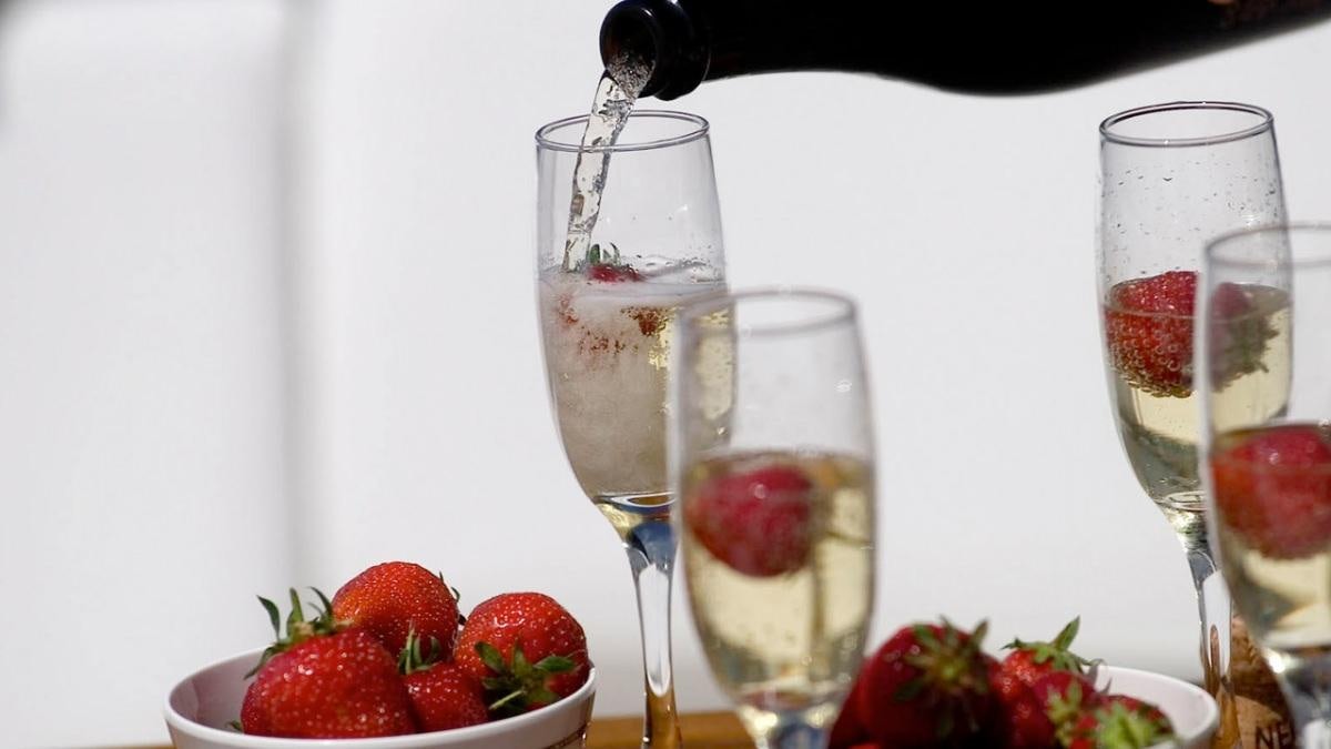 a glass of wine next to a group of strawberries aboard MUSTIQUE Yacht for Charter