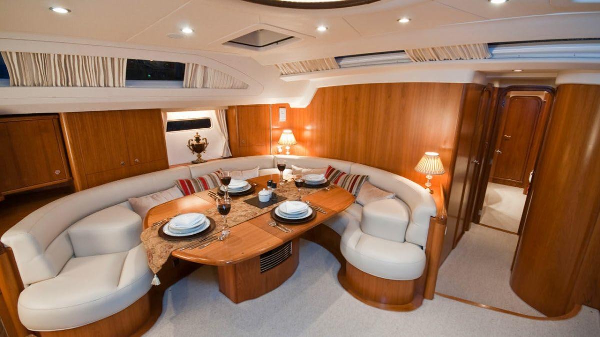 a living room with a table and chairs aboard MUSTIQUE Yacht for Charter