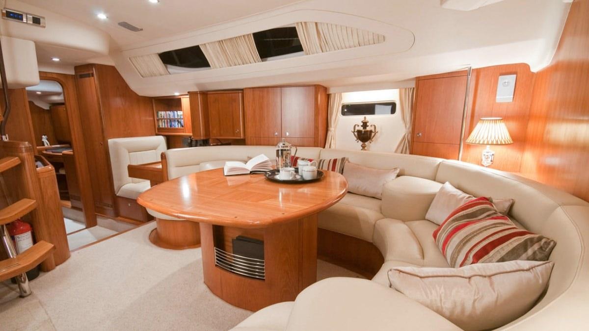 a living room with a table and couches aboard MUSTIQUE Yacht for Charter