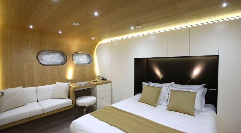 a room with a bed and a television aboard OCEAN SAPPHIRE Yacht for Charter