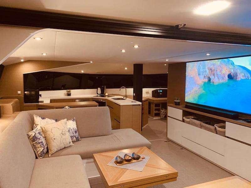 a living room with a large screen aboard LA LINEA Yacht for Charter