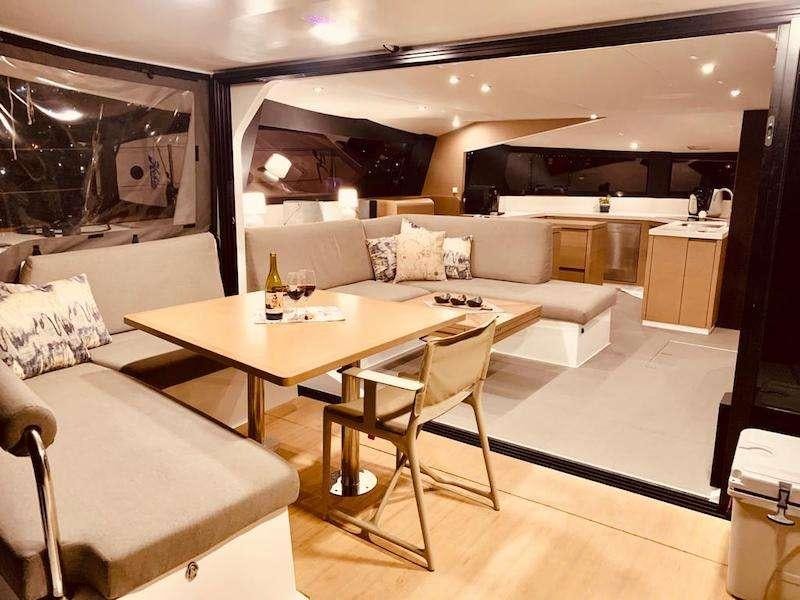 a living room with a table and couches aboard LA LINEA Yacht for Charter