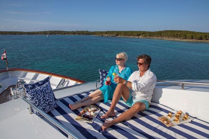 a man and woman sitting on a boat with a woman eating aboard LADY VICTORIA Yacht for Charter