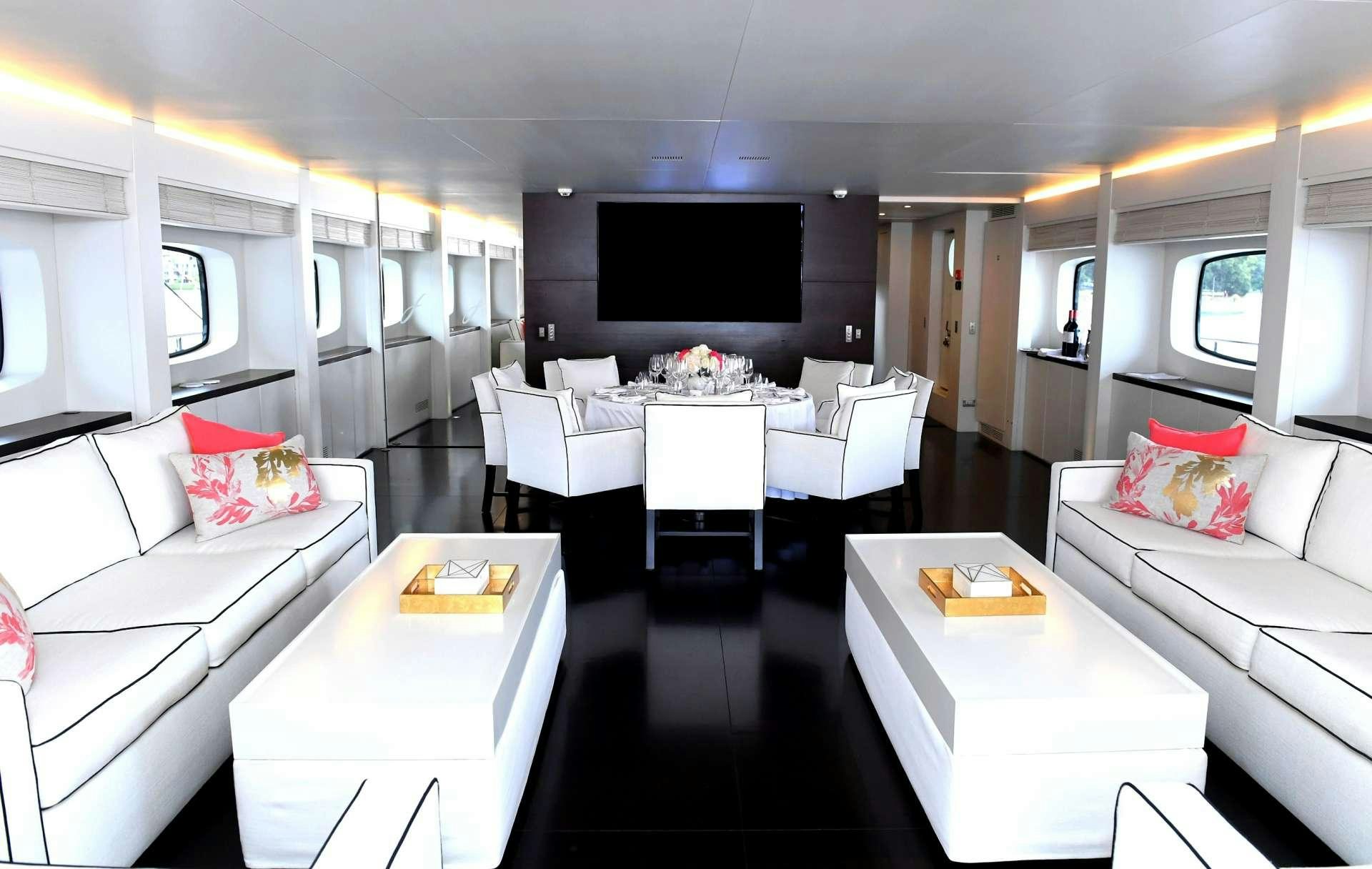a room with white couches and a television aboard IMPULSIVE Yacht for Charter