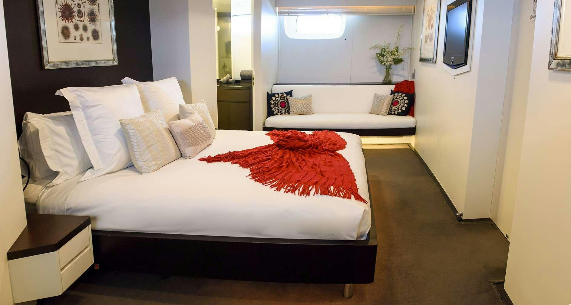 a bed with white sheets aboard IMPULSIVE Yacht for Charter