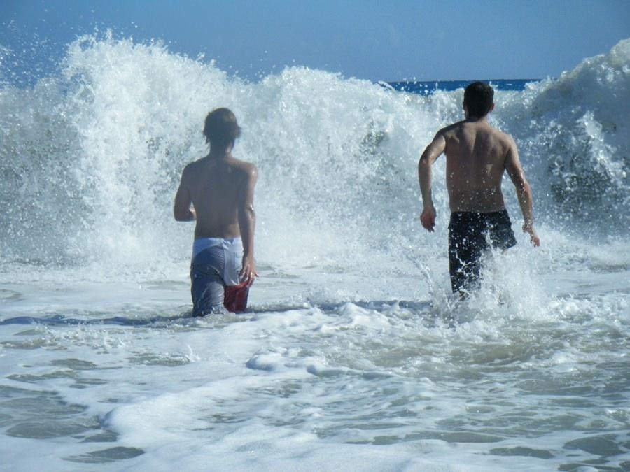 a couple of people walking into the water with a large wave aboard ANAHITA Yacht for Charter