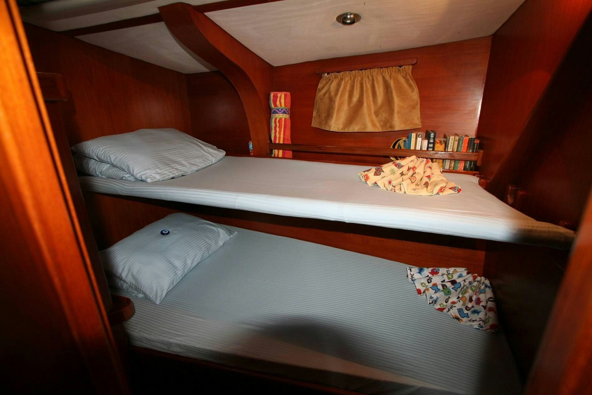 a bed with a table and pillows aboard ANAHITA Yacht for Charter