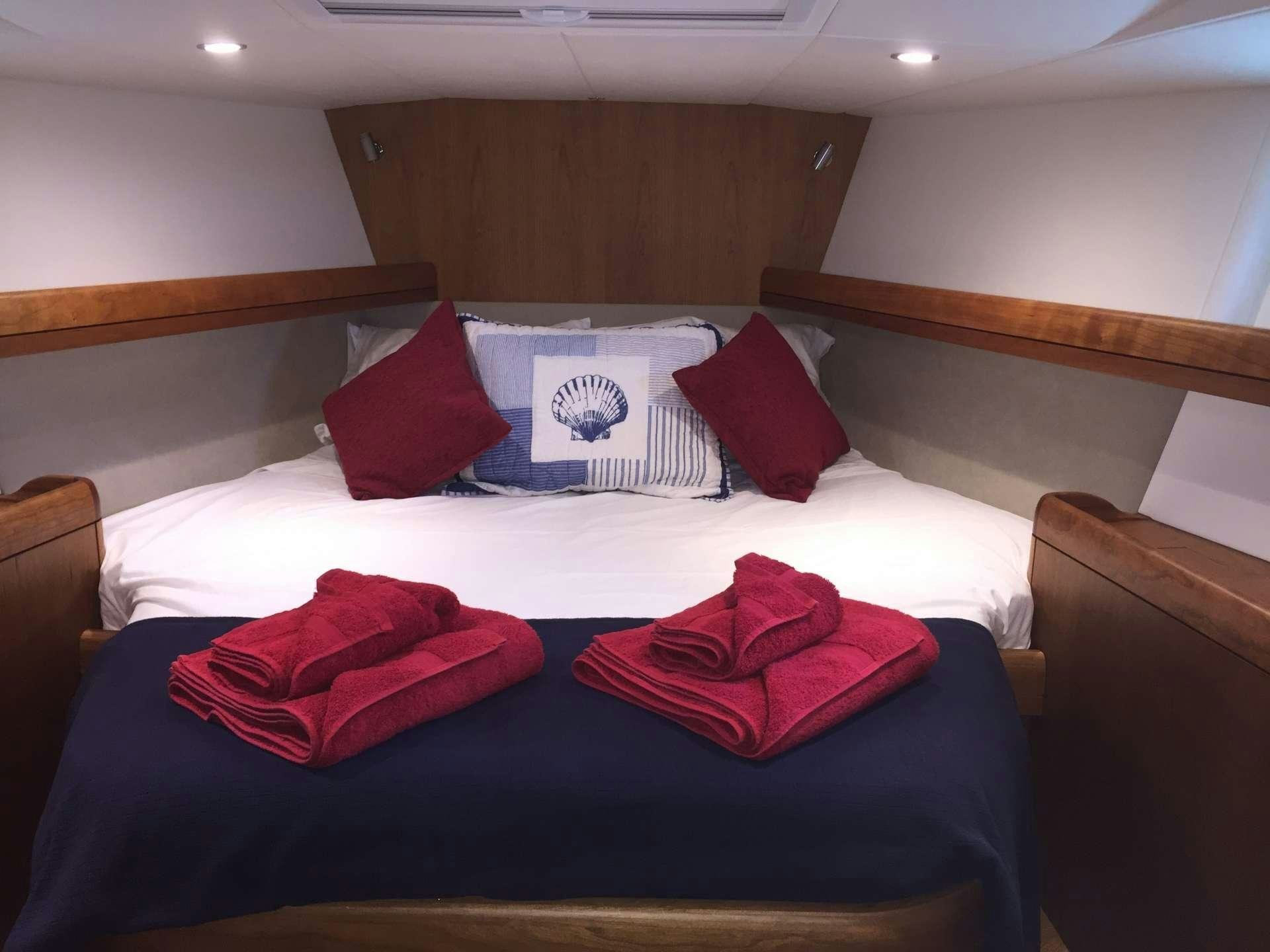 a bed with red pillows aboard SPIRIT Yacht for Charter