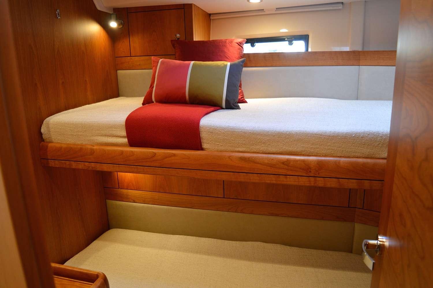 a bed with red pillows aboard SPIRIT Yacht for Charter