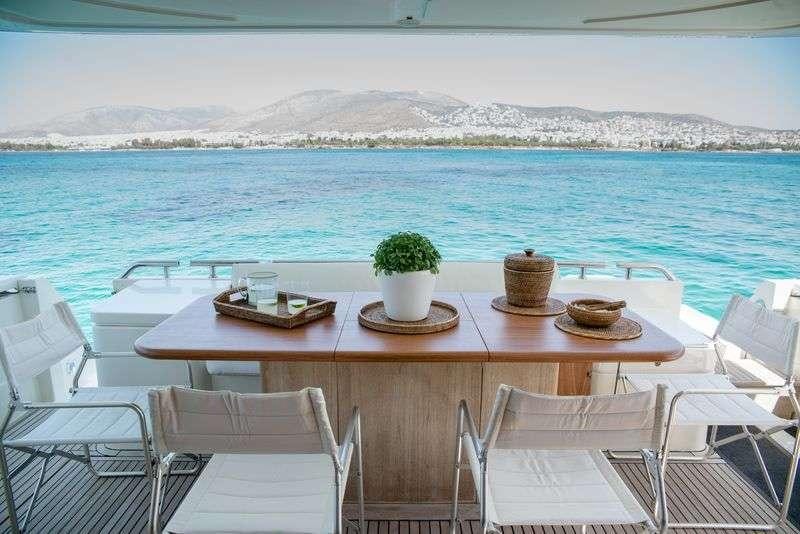 a table with chairs on it by the water aboard ANANAS Yacht for Charter