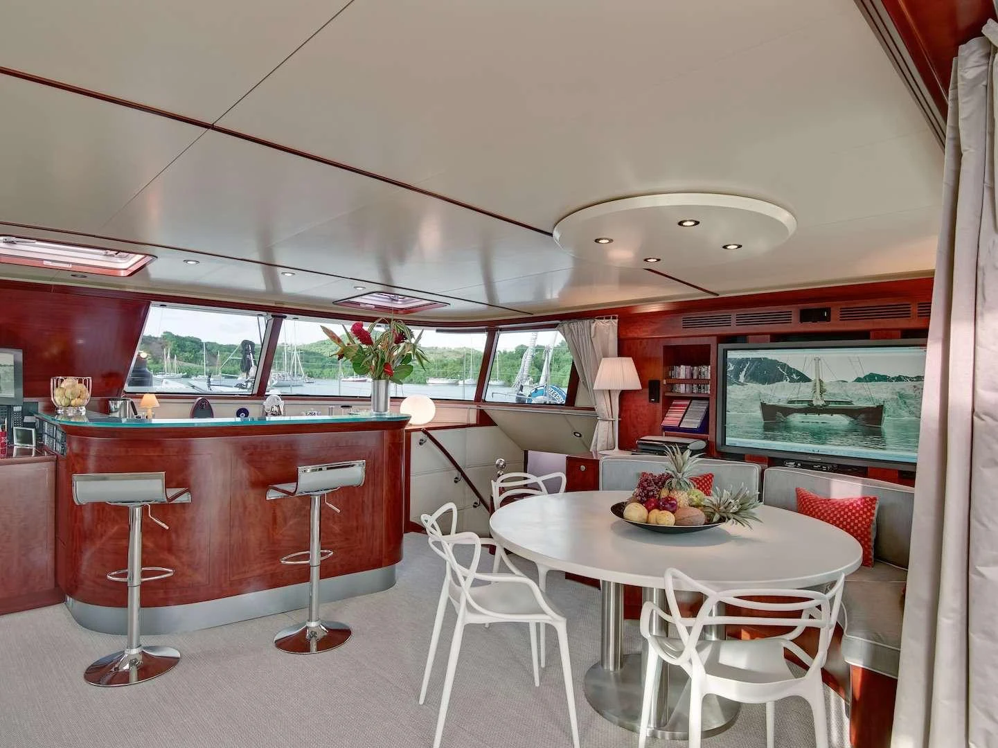 The yacht's salon features a stylish dining area with modern furnishings and large windows offering scenic views. aboard AZIZAM Yacht for Charter