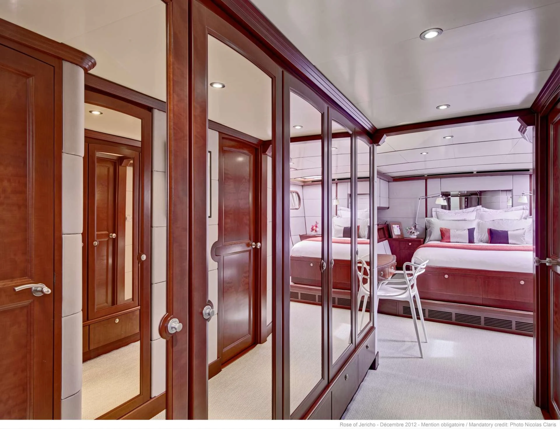 The image showcases a luxurious stateroom with elegant wooden finishes and a comfortable bed. aboard AZIZAM Yacht for Charter
