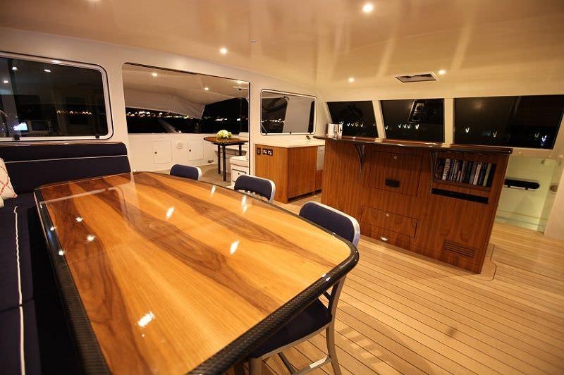 a large conference room with a wood table and chairs aboard SLIM Yacht for Charter
