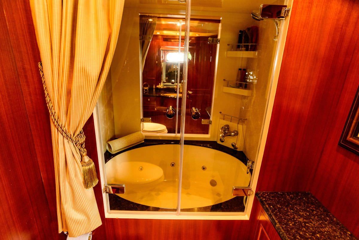 a bathroom with a tub and a mirror aboard KENTUCKY BELLE Yacht for Charter