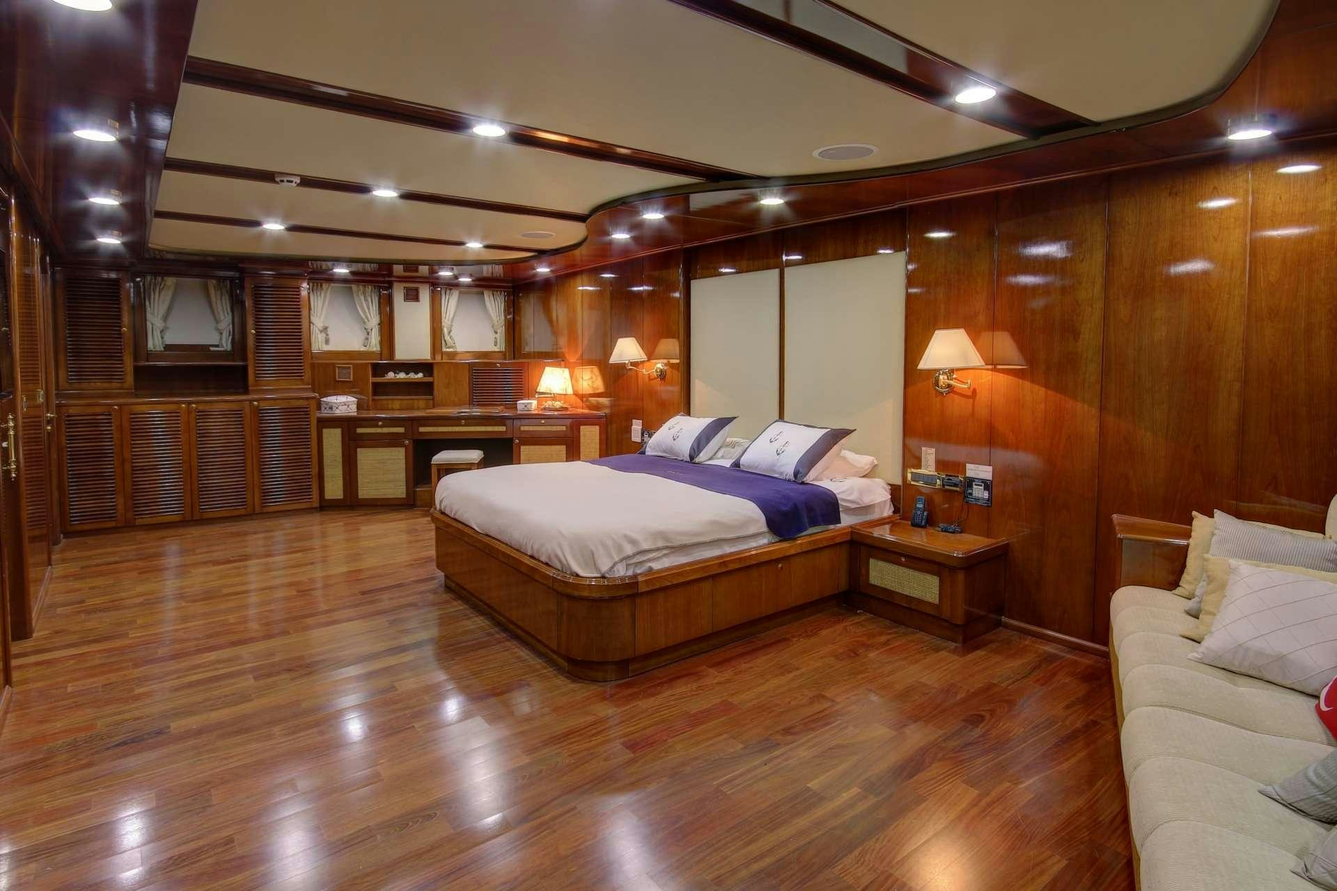 a large room with a bed and a table aboard SEA DREAM Yacht for Charter