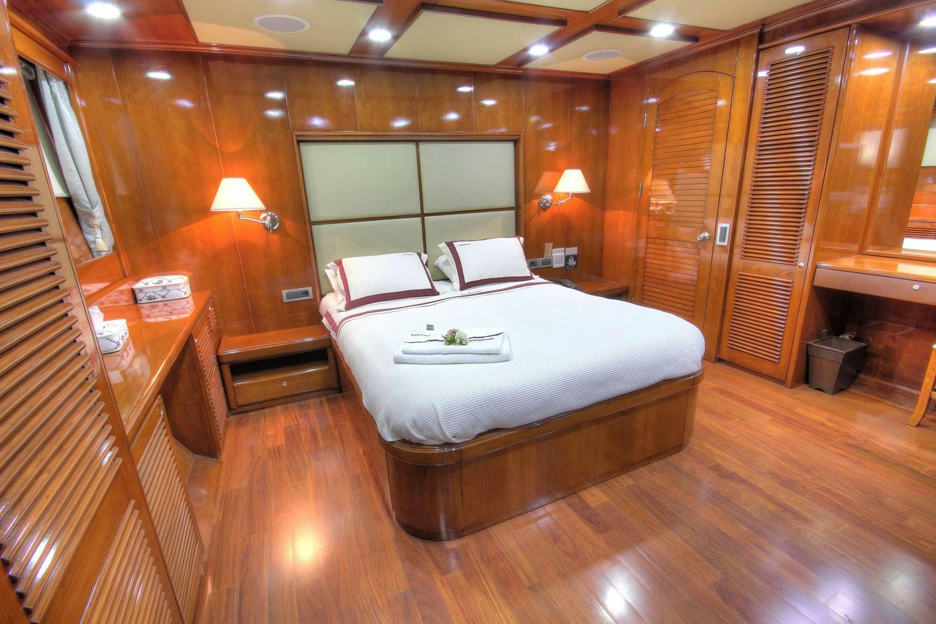 a bedroom with a bed and a desk aboard SEA DREAM Yacht for Charter