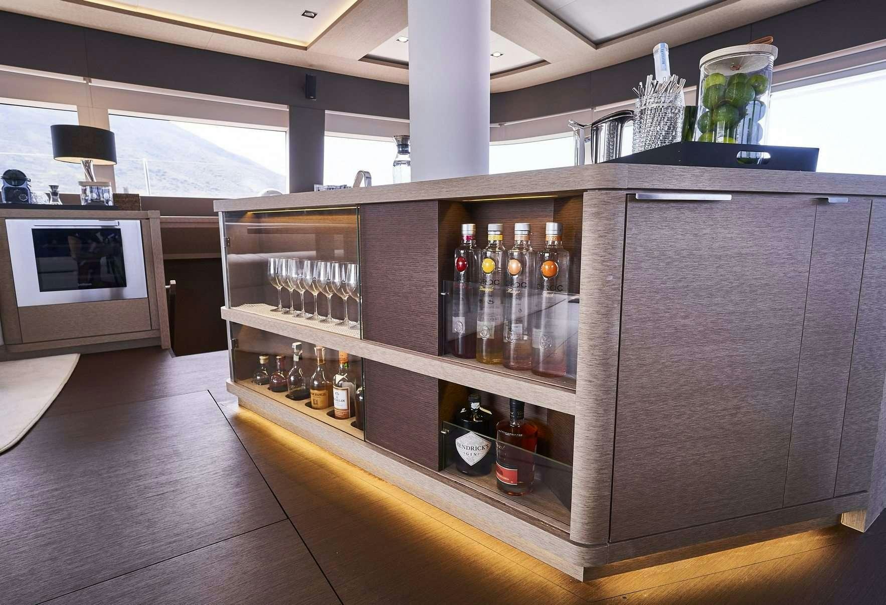 a wooden cabinet with bottles of liquor aboard BABAC Yacht for Charter
