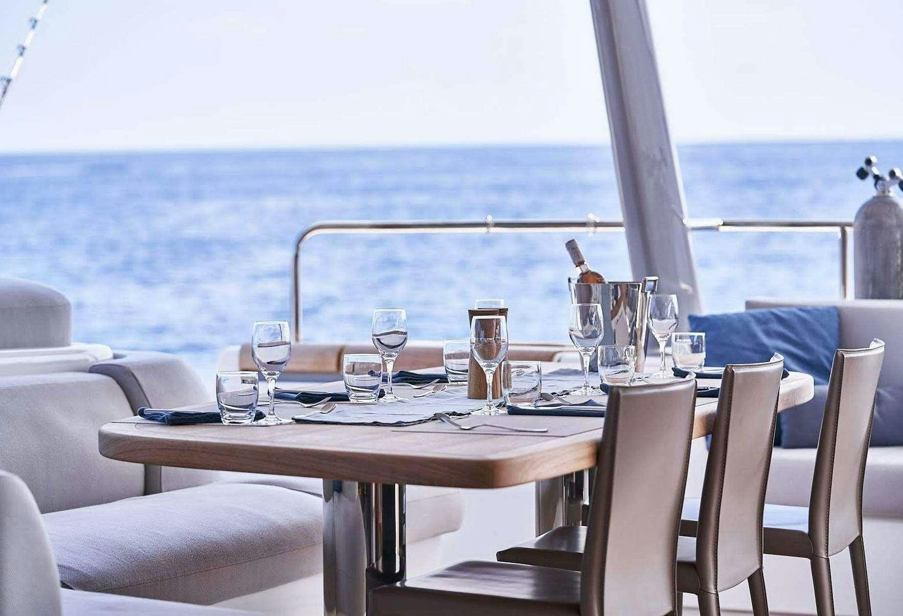 a table set with wine glasses aboard BABAC Yacht for Charter