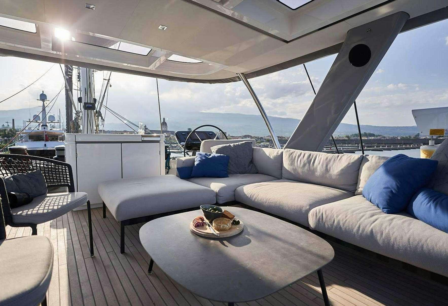 a boat with a couch and a table aboard BABAC Yacht for Charter