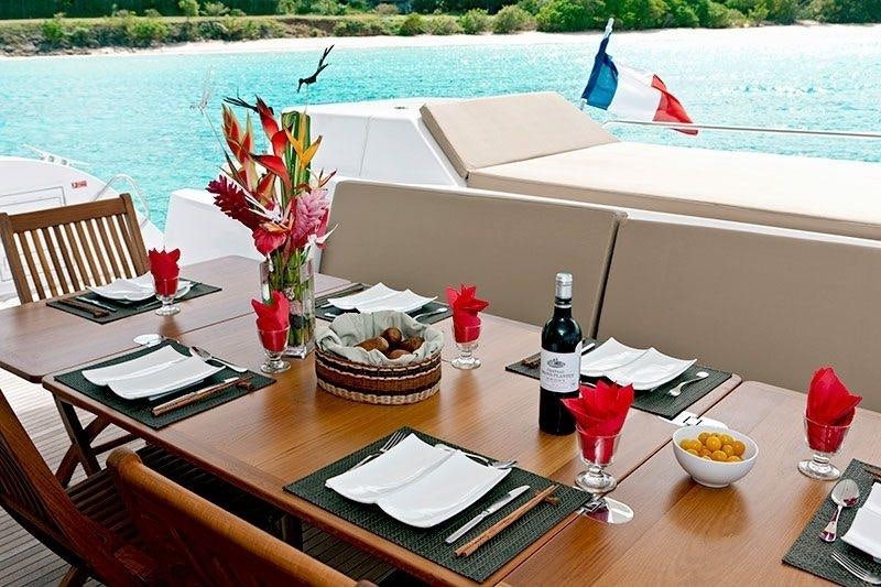 a table with a flower vase and wine bottles on it aboard ALIVE Yacht for Charter