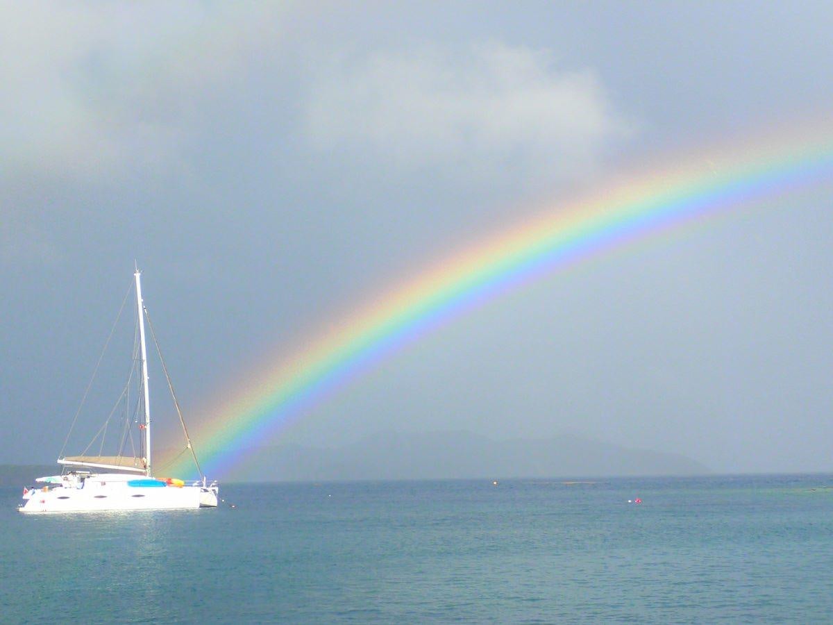 a rainbow over a boat in the water aboard ALIVE Yacht for Charter
