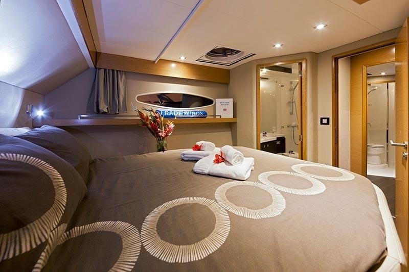 a large bed with a round white pillow on it aboard ALIVE Yacht for Charter