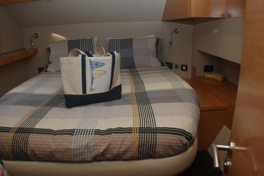 a bed with a blue and white striped pillow aboard ALIVE Yacht for Charter
