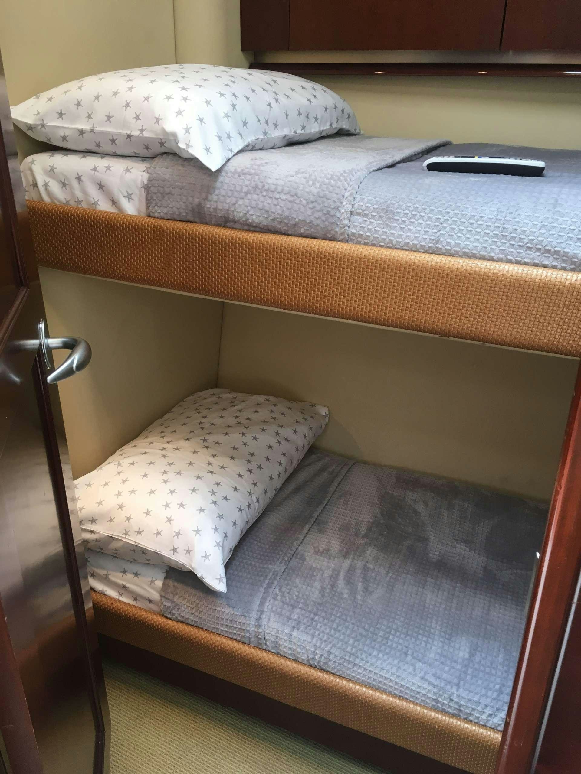 a bed with white sheets aboard FUN CLUB Yacht for Charter